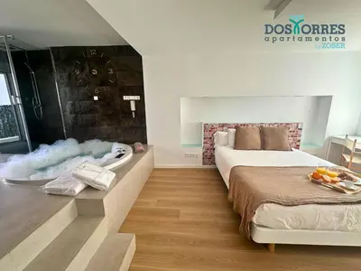 Cama o camas de una habitación en Suite Dos Torres Édoras con jacuzzi privado y parking gratuito en el centro