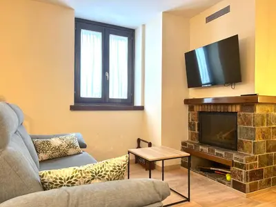 Una televisión o centro de entretenimiento en Apartament encantador amb llar de foc by RURAL D'ÀNEU