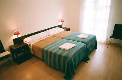 Cama o camas de una habitación en Apartamentos Auhabitat Zaragoza, edificio de apartamentos turísticos