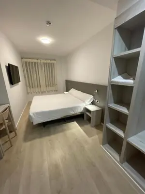 Cama o camas de una habitación en Hostal Pirineos Ainsa
