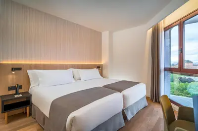 Cama o camas de una habitación en Occidental Pamplona