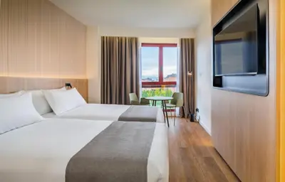 Cama o camas de una habitación en Occidental Pamplona